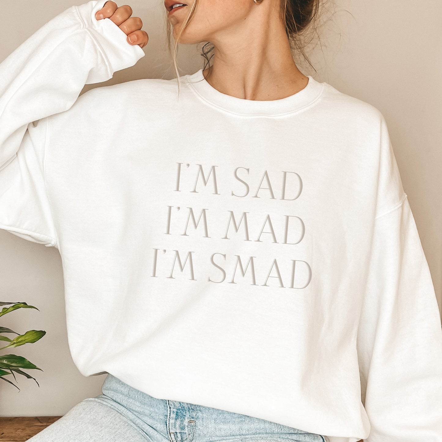 The front of the sweatshirt proudly displays the phrase "I’m Sad. I’m Mad. I’m Smad." in a bold and eye-catching font. The design is not just a fashion statement; it's a conversation starter that promotes mental health awareness and destigmatizes the spectrum of feelings we all experience.