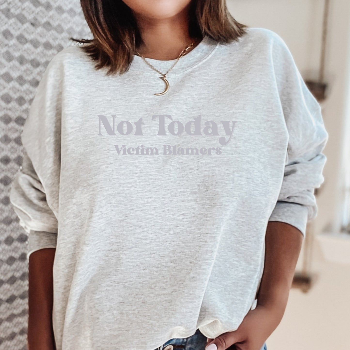 The front of the sweatshirt proudly displays the phrase "Not Today Victim Blamers" in a bold and eye-catching font. This message serves as a reminder that we reject victim-blaming and support those who have faced injustice.