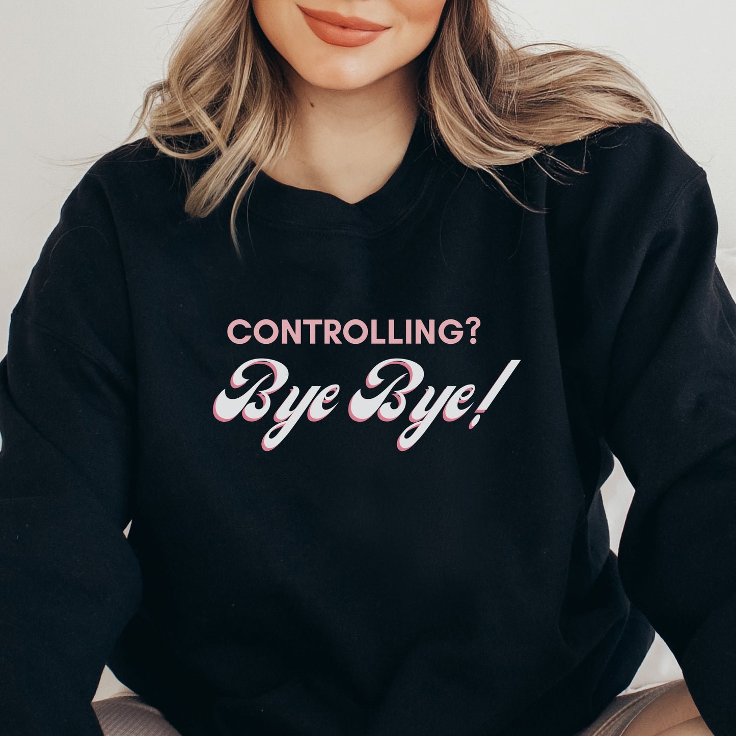The front of the sweatshirt proudly displays the phrase "Controlling? Bye Bye!" in a bold and eye-catching font. This message serves as a reminder that love is not controlling. Tailored for domestic violence and teen dating violence advocates.