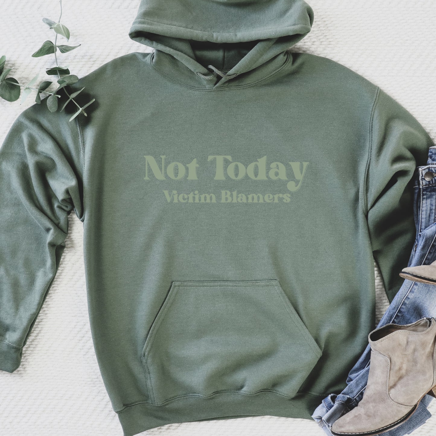 The front of the hooded sweatshirt proudly displays the phrase Not Today Victim Blamers in a bold and eye catching font. This message serves as a reminder that we reject victim blaming and support those who have faced injustice.