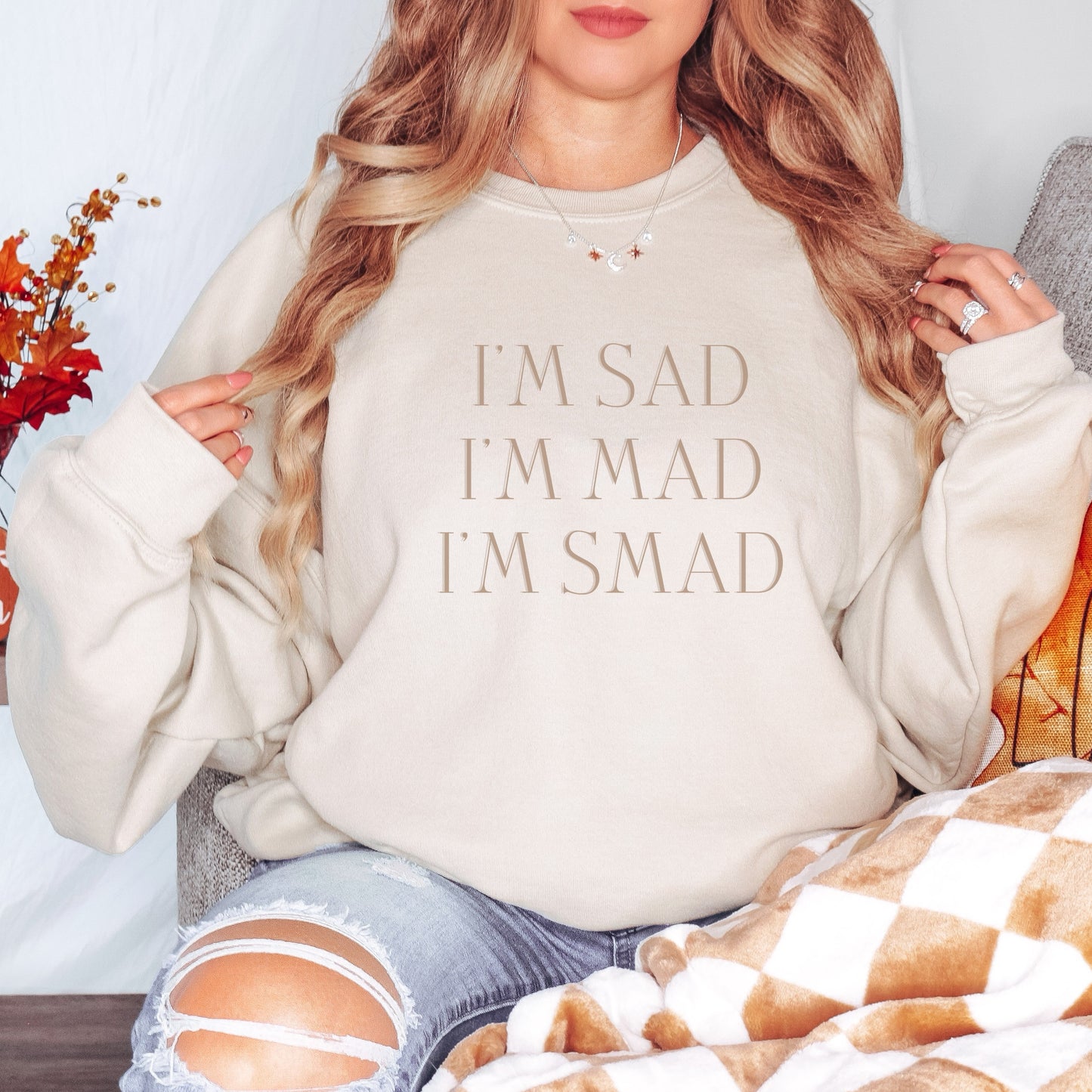 The front of the sweatshirt proudly displays the phrase "I’m Sad. I’m Mad. I’m Smad." in a bold and eye-catching font. The design is not just a fashion statement; it's a conversation starter that promotes mental health awareness and destigmatizes the spectrum of feelings we all experience.