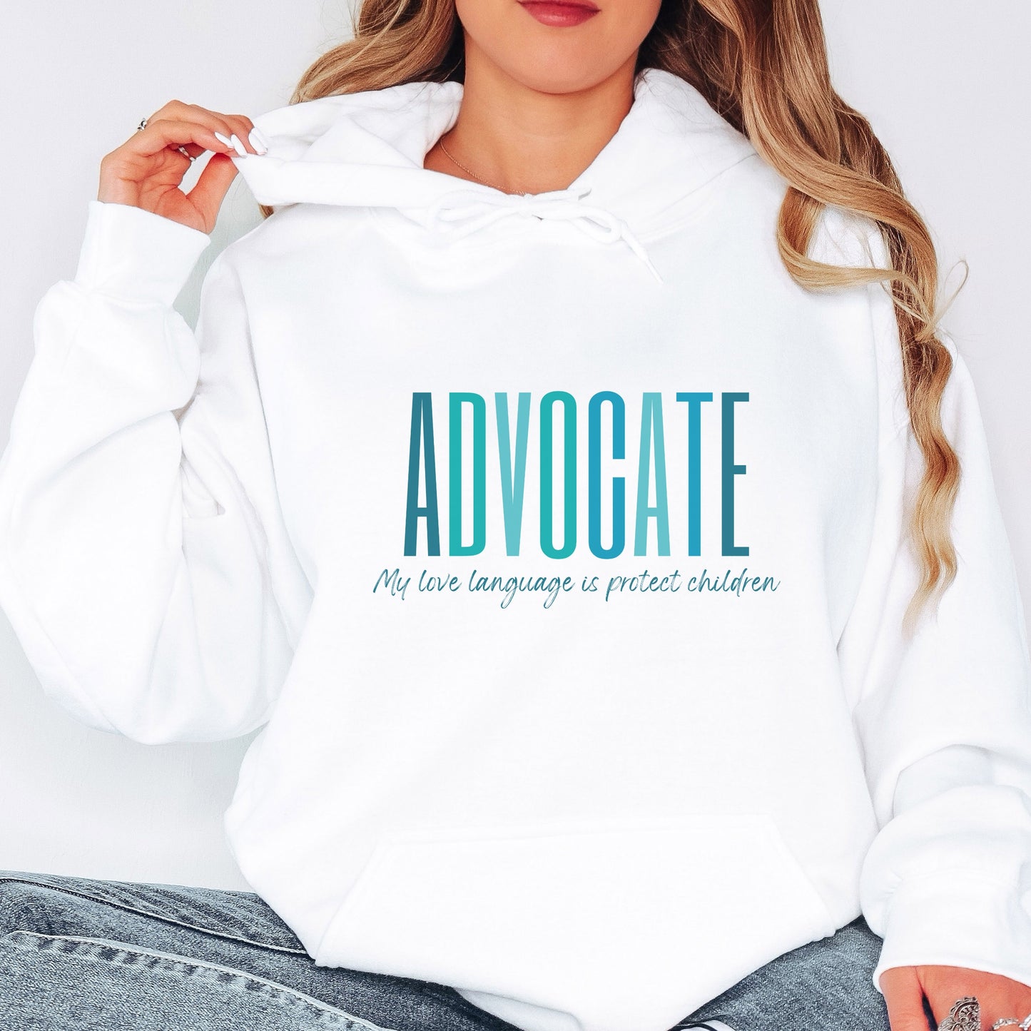 Front and center of this hooded sweatshirt, the bold message declares, "ADVOCATE: my love language is protect children." Artfully designed in varying shades of blue, this impactful phrase encapsulates the essence of your commitment to safeguarding children and promoting their well-being. Perfect for child advocates, champions of children’s mental health, and for Child Abuse Awareness and Prevention Month