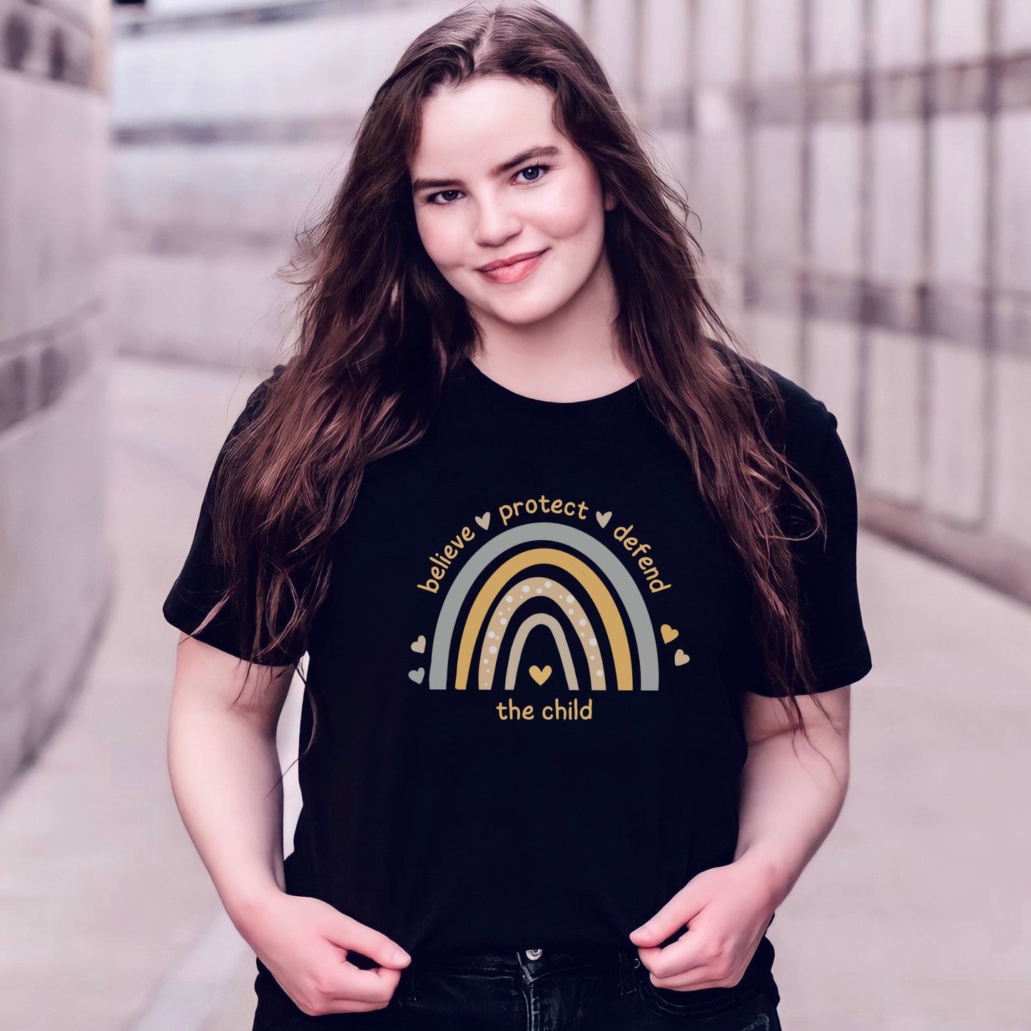 The front of the tee displays a boho rainbow with the phrase Believe Protect Defend The Child. A powerful message that underscores the importance of safeguarding children's rights and well being. Perfect for child advocates and Child Abuse Awareness and Prevention Month (CAAPM)