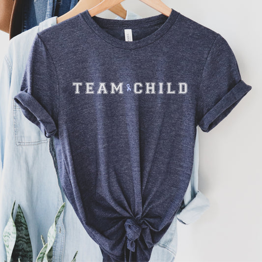 Our exclusive t-shirt has ‘Team Child’ on the front in a bold font with the blue child abuse awareness ribbon between the words. This impactful phrase encapsulates the essence of your commitment to safeguarding children and promoting their well-being. Perfect for child advocates, champions of children’s mental health, and for Child Abuse Awareness and Prevention Month (CAPM)