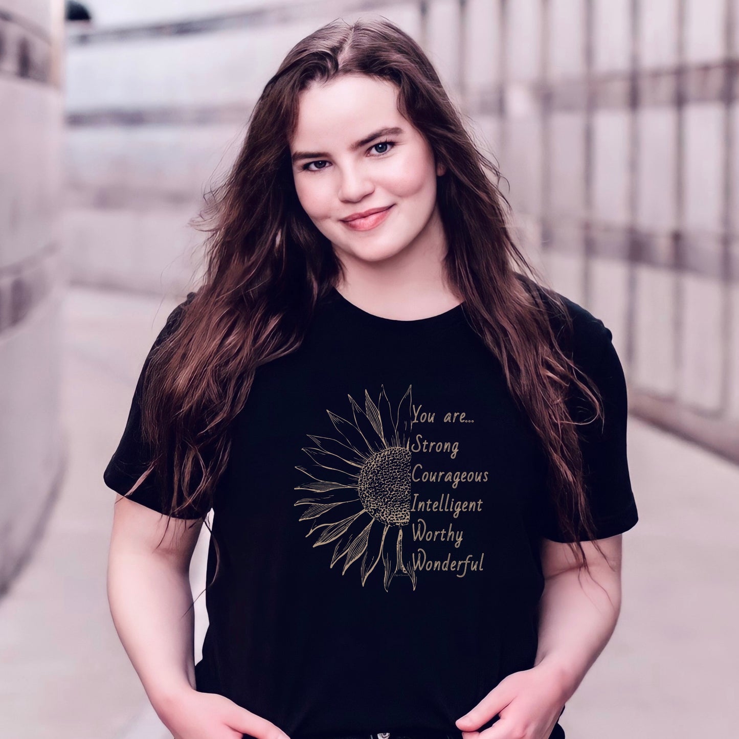 This thoughtfully designed shirt features a vibrant sunflower, symbolizing resilience and growth, accompanied by the powerful mantra: "You are strong, courageous, intelligent, worthy, and wonderful."