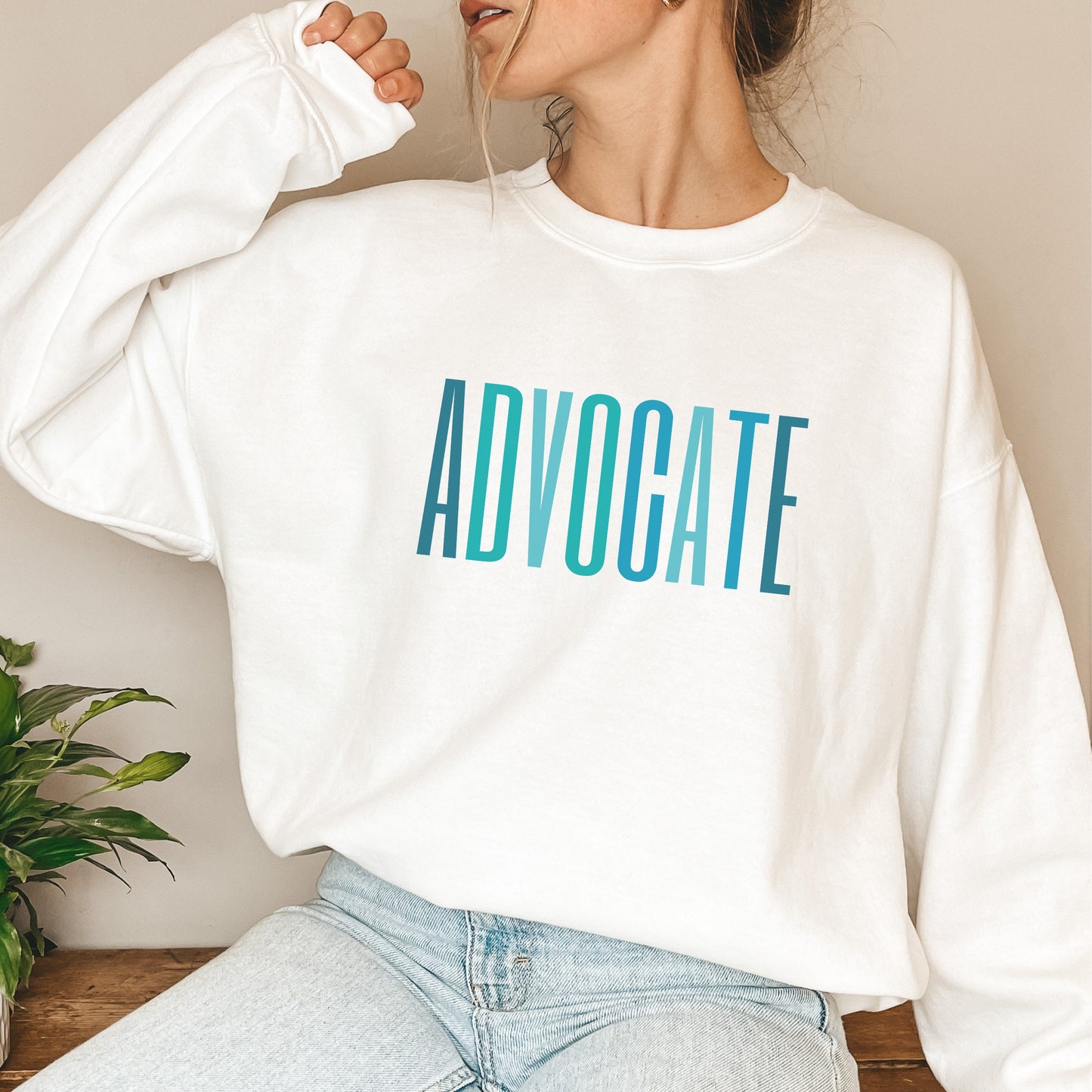 The front of the sweatshirt proudly displays the word ADVOCATE in a bold and eye catching font in varying shades of blue which is the color of child advocacy. It is a wearable symbol of your dedication to a world where all children are loved, cherished, and protected.