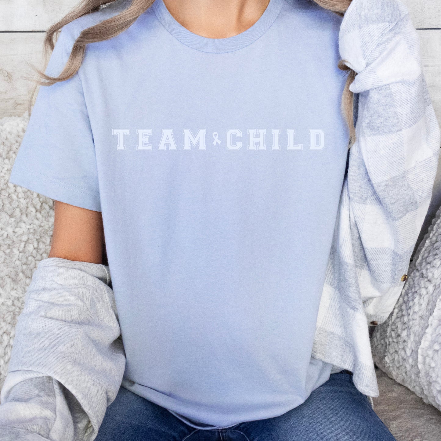 Our exclusive t-shirt has ‘Team Child’ on the front in a bold font with the blue child abuse awareness ribbon between the words. This impactful phrase encapsulates the essence of your commitment to safeguarding children and promoting their well-being. Perfect for child advocates, champions of children’s mental health, and for Child Abuse Awareness and Prevention Month (CAPM)