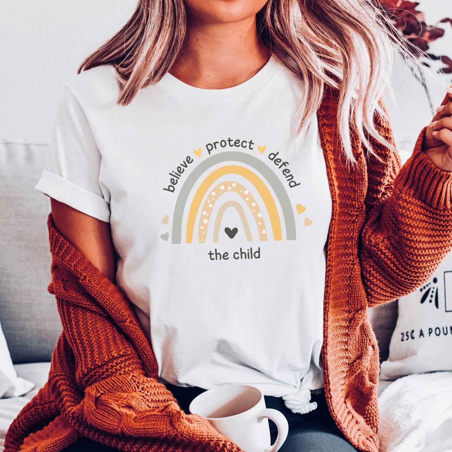 The front of the tee displays a boho rainbow with the phrase Believe Protect Defend The Child. A powerful message that underscores the importance of safeguarding children's rights and well being. Perfect for child advocates and Child Abuse Awareness and Prevention Month (CAAPM)