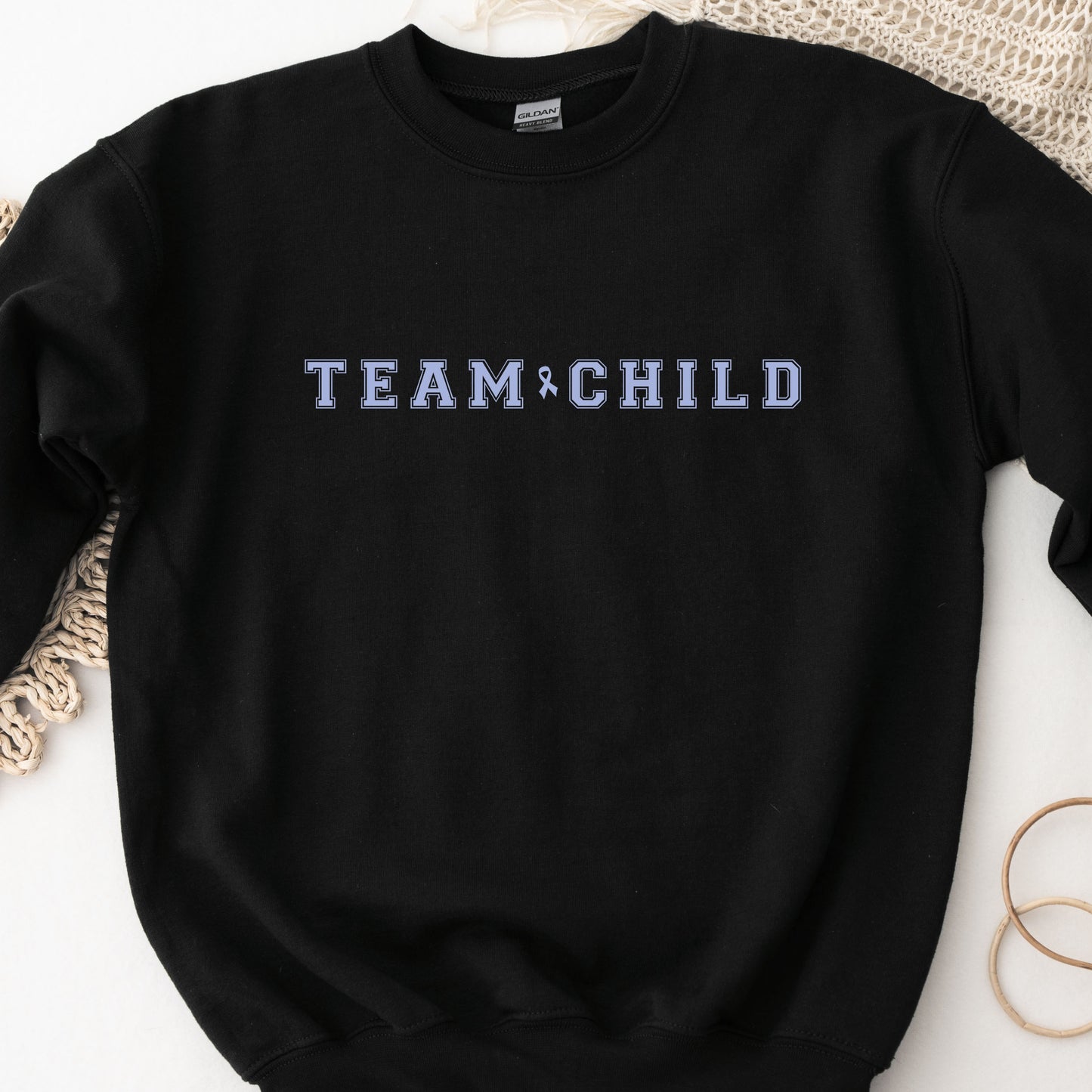 Our exclusive sweatshirt has ‘Team Child’ on the front in a bold font with the blue child abuse awareness ribbon between the words. This impactful phrase encapsulates the essence of your commitment to safeguarding children and promoting their well-being. Perfect for child advocates, champions of children’s mental health, and for Child Abuse Awareness and Prevention Month (CAPM)