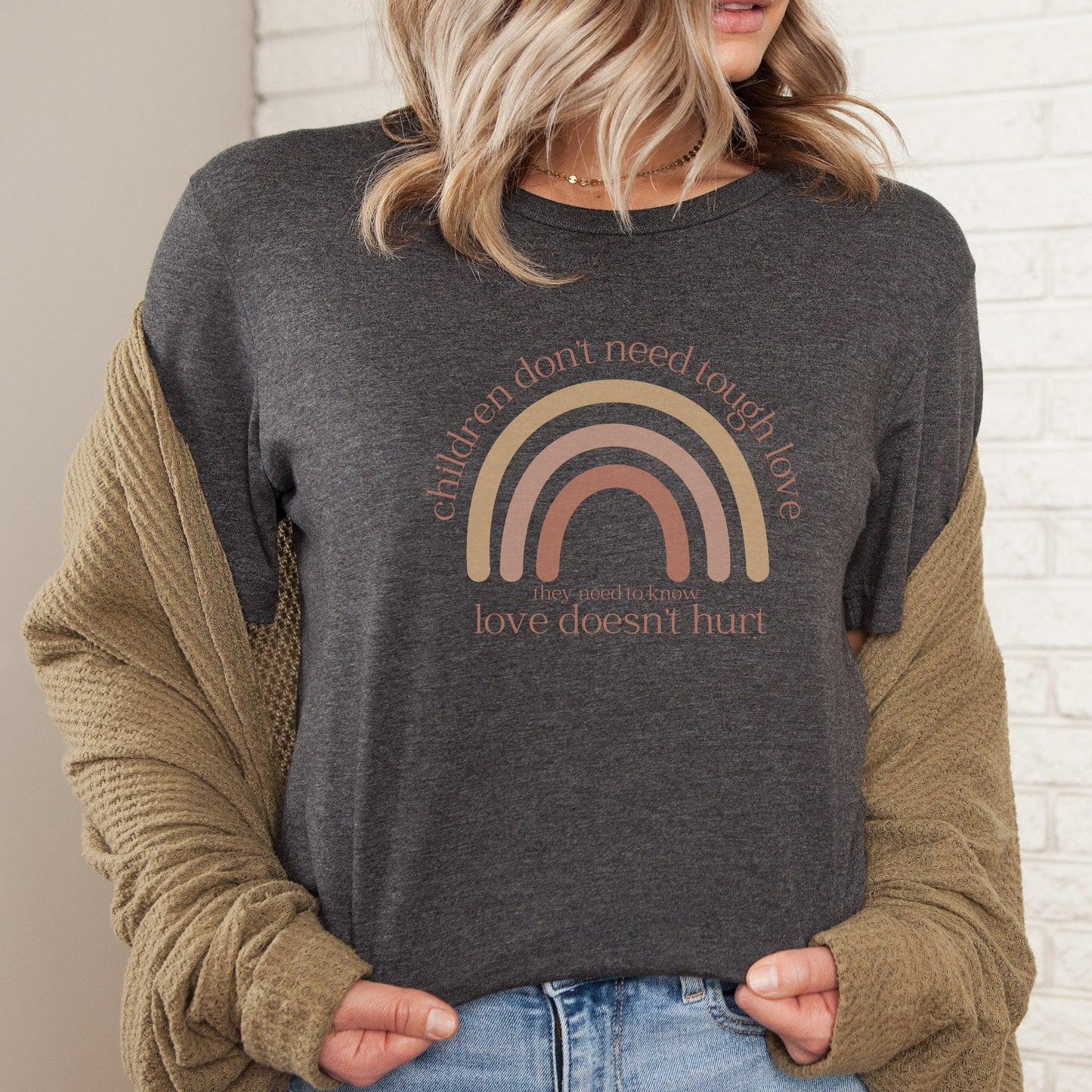 The front of the t-shirt has a beautiful boho rainbow that boldly declares, "Children don't need tough love, they need to know love doesn't hurt." It serves as a rallying cry for advocates, emphasizing the importance of fostering environments where love is synonymous with safety and support. Perfect for child advocates, family advocates, and Child Abuse Awareness and Prevention Month CAPM