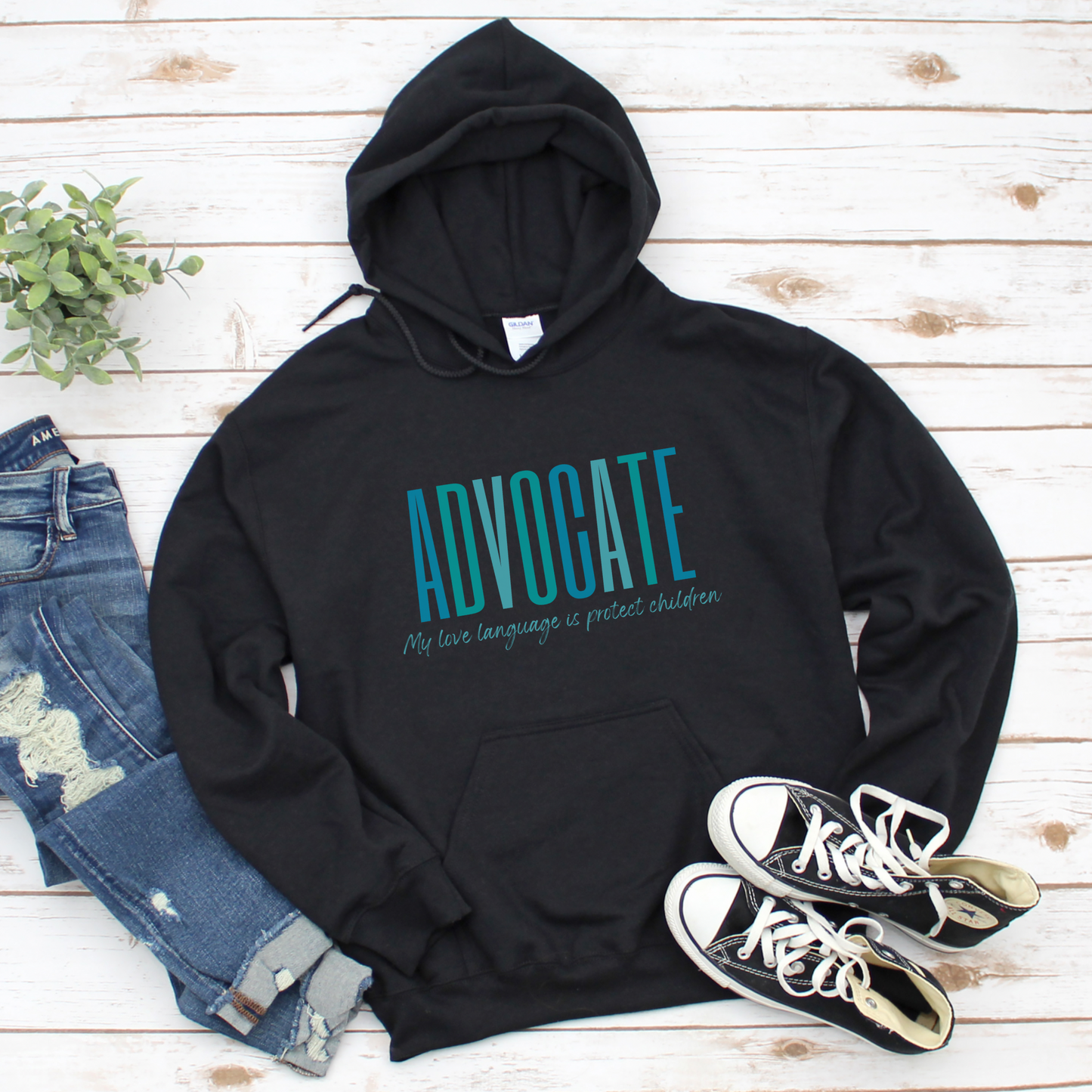 Front and center of this hooded sweatshirt, the bold message declares, "ADVOCATE: my love language is protect children." Artfully designed in varying shades of blue, this impactful phrase encapsulates the essence of your commitment to safeguarding children and promoting their well-being. Perfect for child advocates, champions of children’s mental health, and for Child Abuse Awareness and Prevention Month
