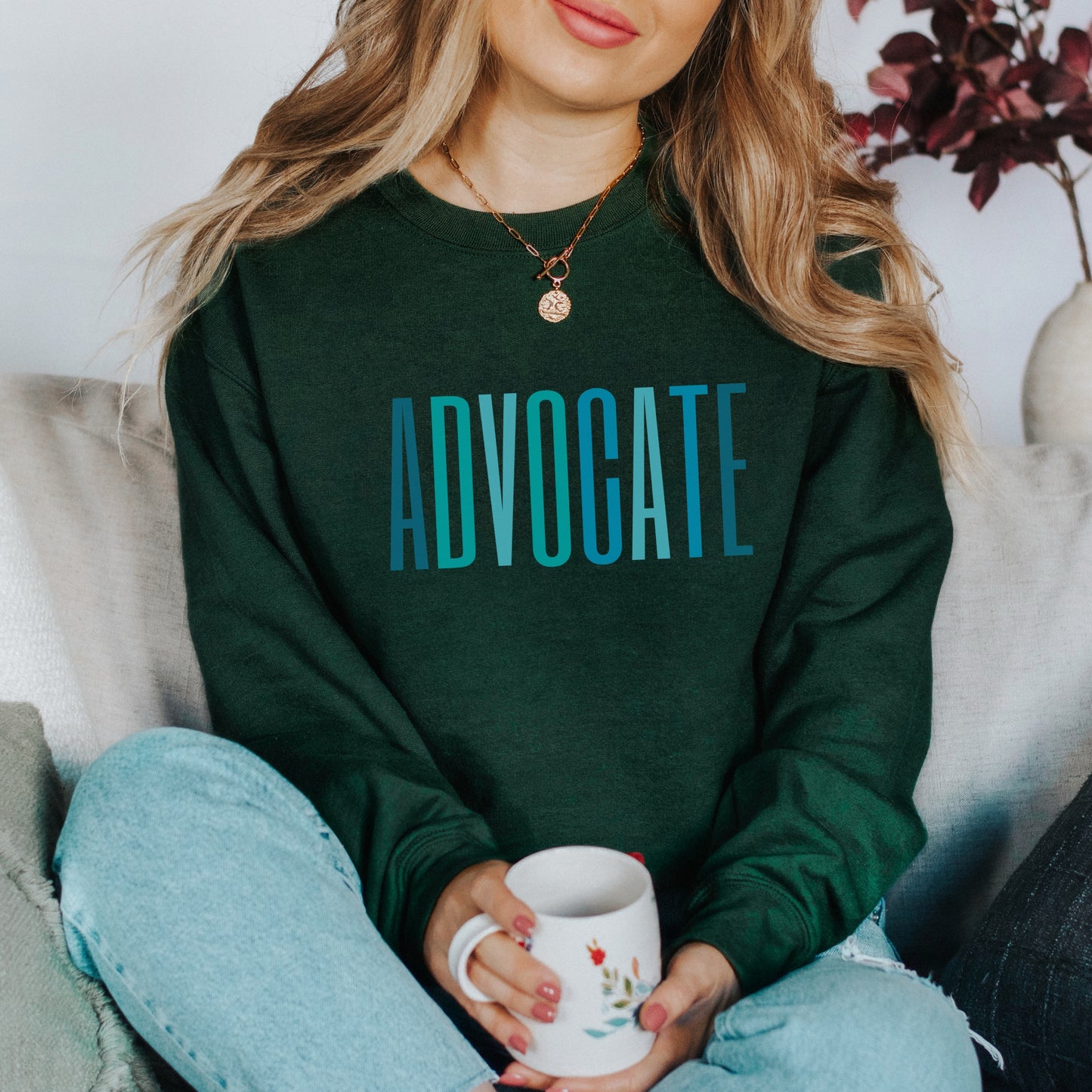 The front of the sweatshirt proudly displays the word ADVOCATE in a bold and eye catching font in varying shades of blue which is the color of child advocacy. It is a wearable symbol of your dedication to a world where all children are loved, cherished, and protected.