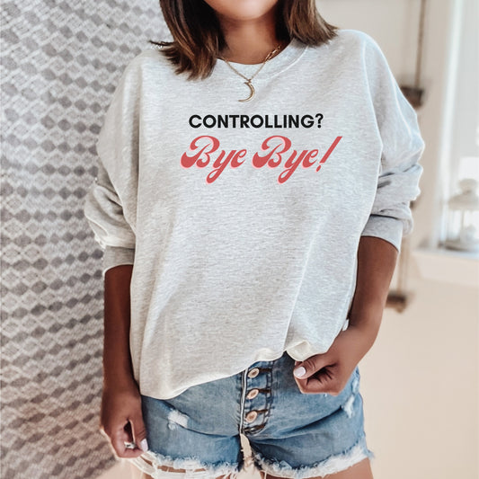 The front of the sweatshirt proudly displays the phrase "Controlling? Bye Bye!" in a bold and eye-catching font. This message serves as a reminder that love is not controlling. Tailored for domestic violence and teen dating violence advocates.