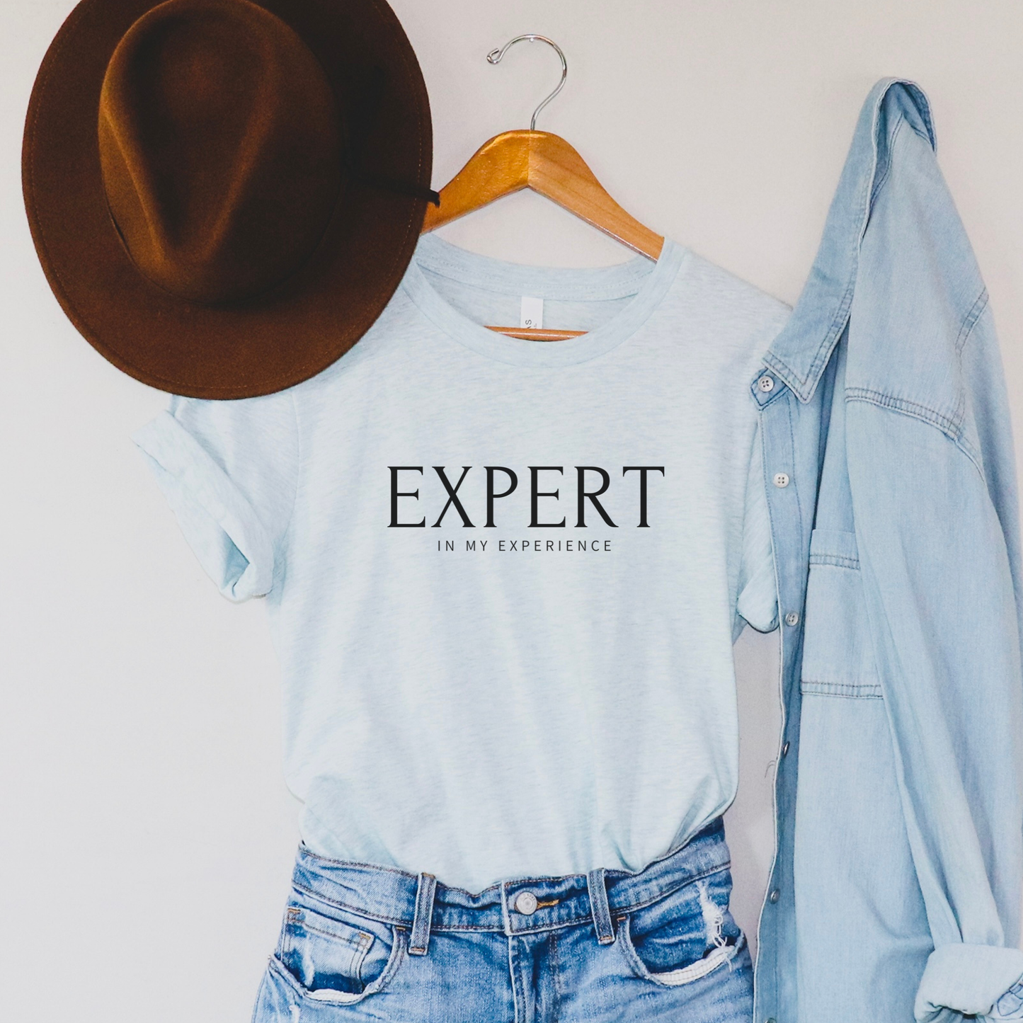 Expert in My Experience t-shirt in heather ice blue with black text. Soft calming empowerment tee for survivors and mental health advocates.
