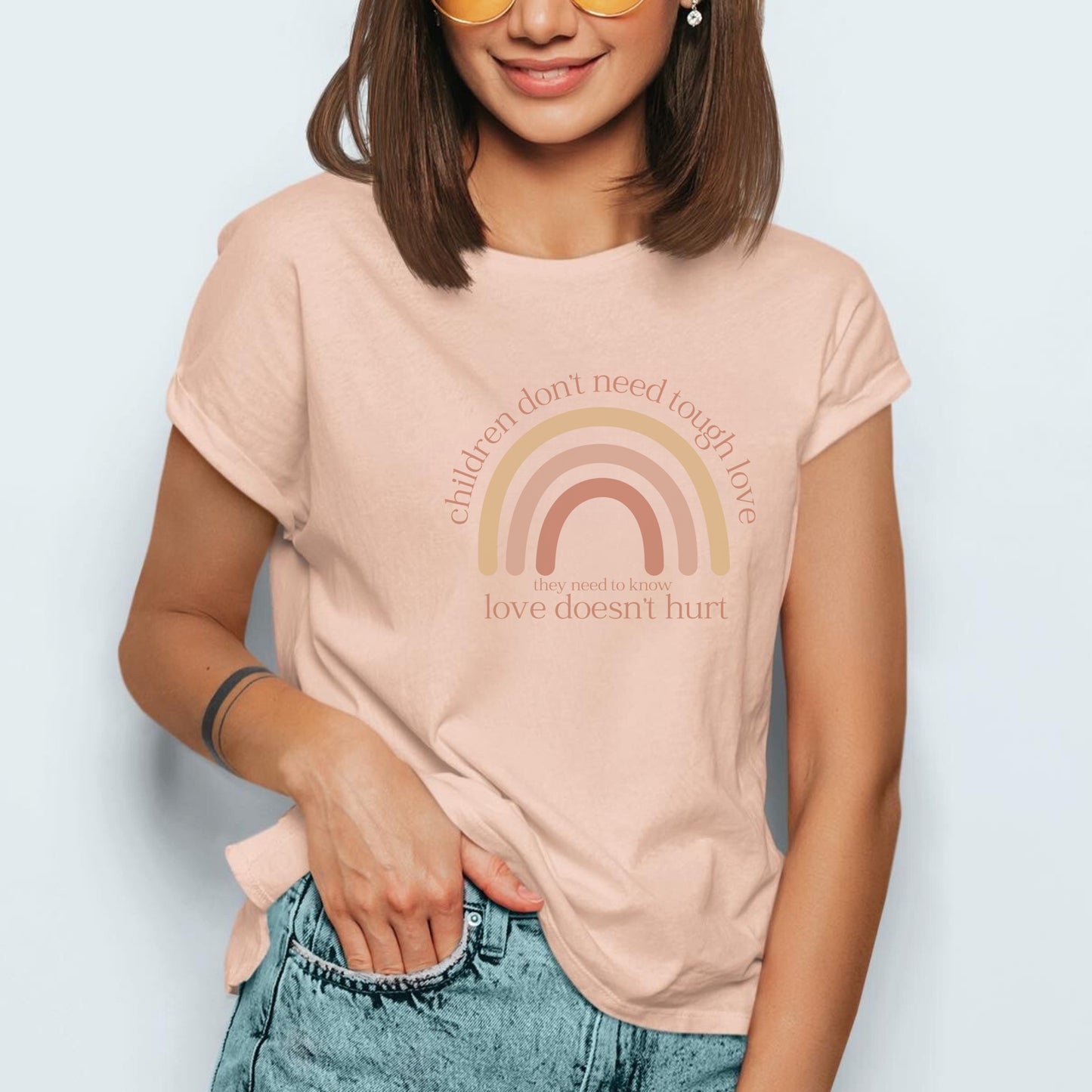 The front of the t-shirt has a beautiful boho rainbow that boldly declares, "Children don't need tough love, they need to know love doesn't hurt." It serves as a rallying cry for advocates, emphasizing the importance of fostering environments where love is synonymous with safety and support. Perfect for child advocates, family advocates, and Child Abuse Awareness and Prevention Month CAPM