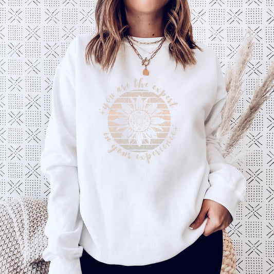 Mental health empowerment with our unique sweatshirt, tailored for survivors and advocates of abuse and trauma. The boho sunflower, a symbol of strength and growth, is surrounded by the powerful message, You are the expert in your experience.