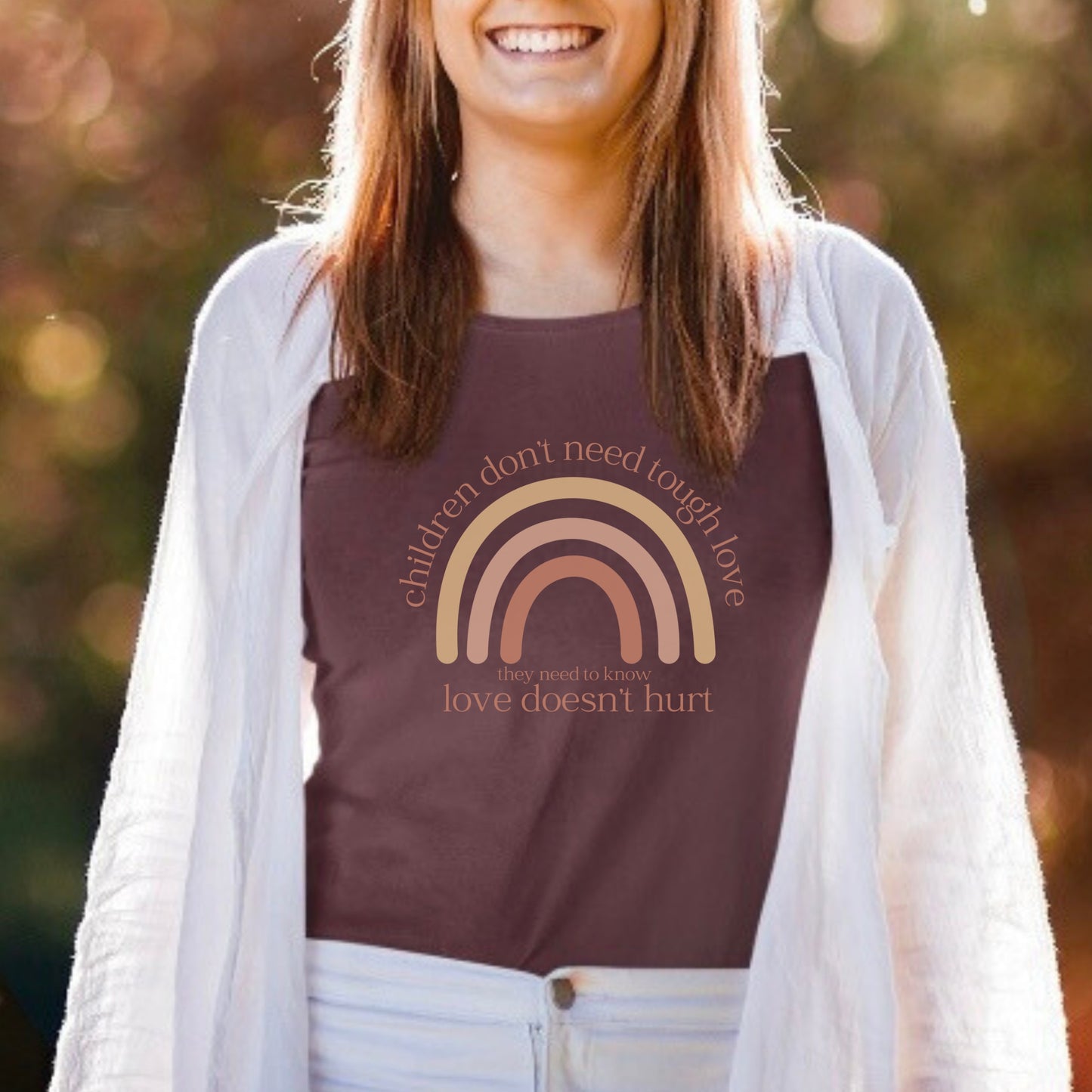 The front of the t-shirt has a beautiful boho rainbow that boldly declares, "Children don't need tough love, they need to know love doesn't hurt." It serves as a rallying cry for advocates, emphasizing the importance of fostering environments where love is synonymous with safety and support. Perfect for child advocates, family advocates, and Child Abuse Awareness and Prevention Month CAPM