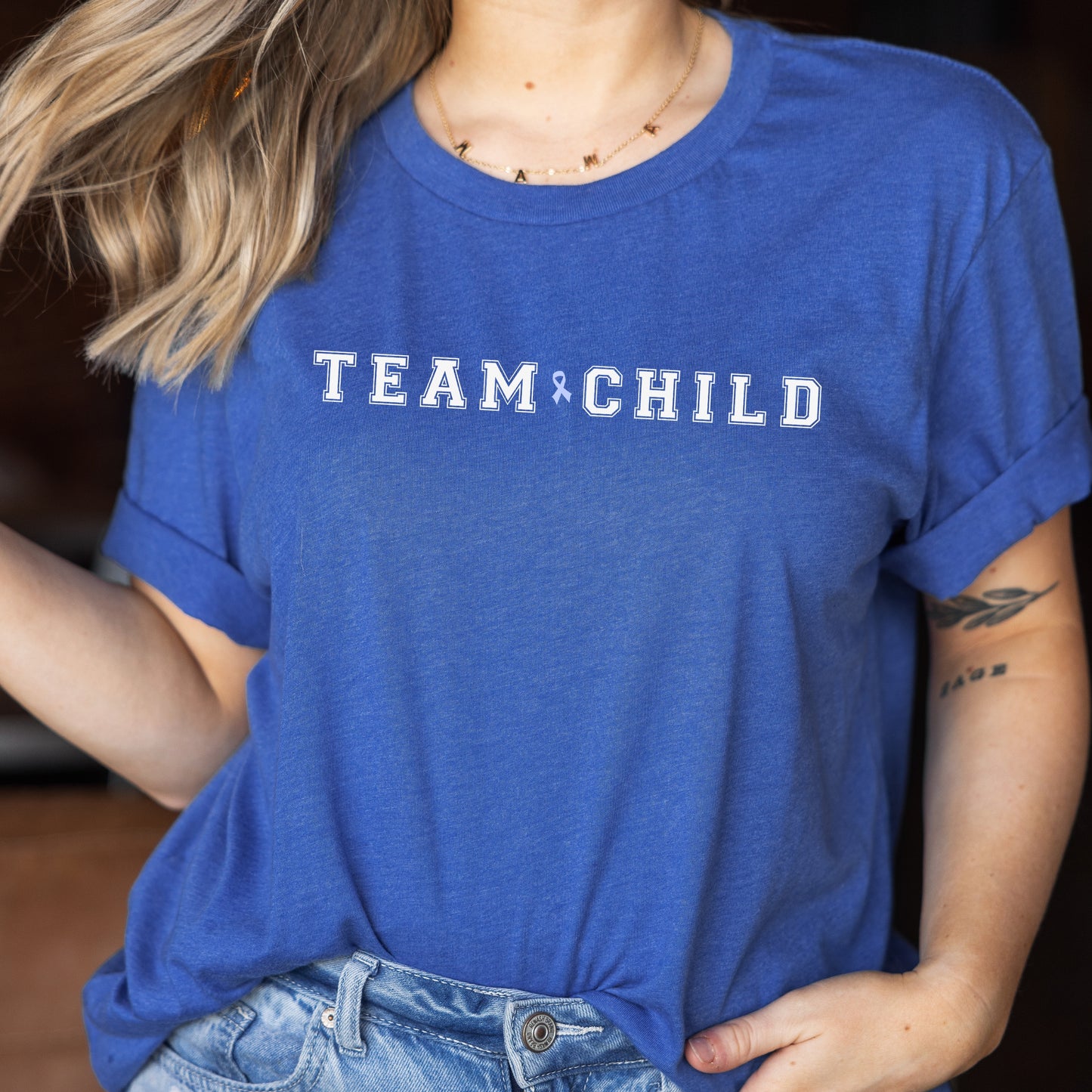 Our exclusive t-shirt has ‘Team Child’ on the front in a bold font with the blue child abuse awareness ribbon between the words. This impactful phrase encapsulates the essence of your commitment to safeguarding children and promoting their well-being. Perfect for child advocates, champions of children’s mental health, and for Child Abuse Awareness and Prevention Month (CAPM)