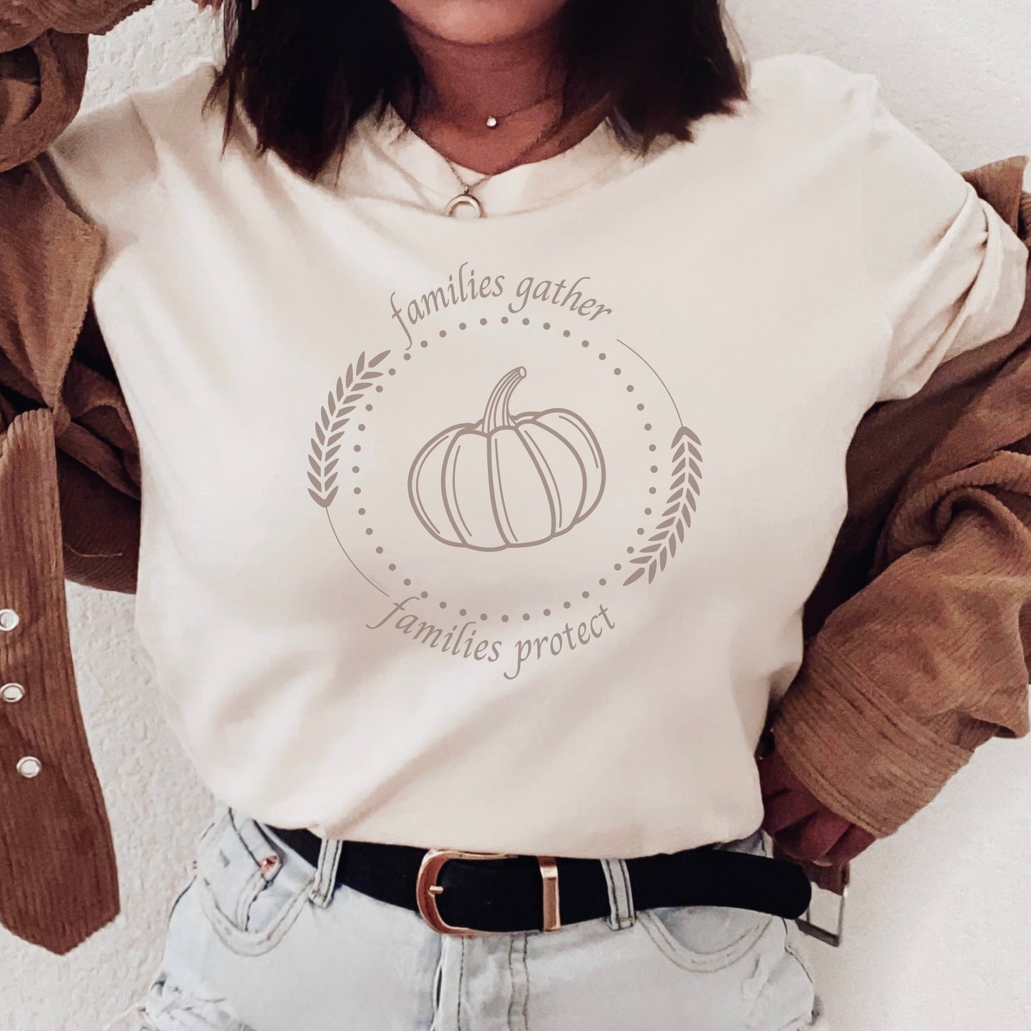 Adorned with a heartwarming autumn-fall harvest pumpkin graphic and the inspiring message Families Gather, Families Protect, this White T-shirt stands as a testament to the unwavering support and protection families should offer to survivors.