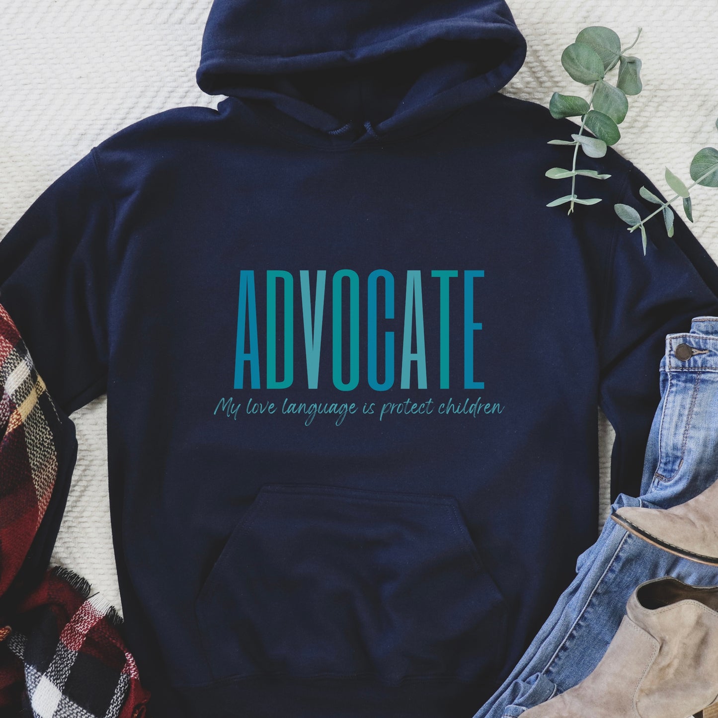 Front and center of this hooded sweatshirt, the bold message declares, "ADVOCATE: my love language is protect children." Artfully designed in varying shades of blue, this impactful phrase encapsulates the essence of your commitment to safeguarding children and promoting their well-being. Perfect for child advocates, champions of children’s mental health, and for Child Abuse Awareness and Prevention Month
