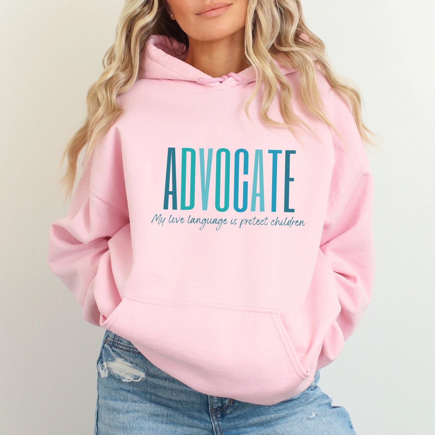 Front and center of this hooded sweatshirt, the bold message declares, "ADVOCATE: my love language is protect children." Artfully designed in varying shades of blue, this impactful phrase encapsulates the essence of your commitment to safeguarding children and promoting their well-being. Perfect for child advocates, champions of children’s mental health, and for Child Abuse Awareness and Prevention Month