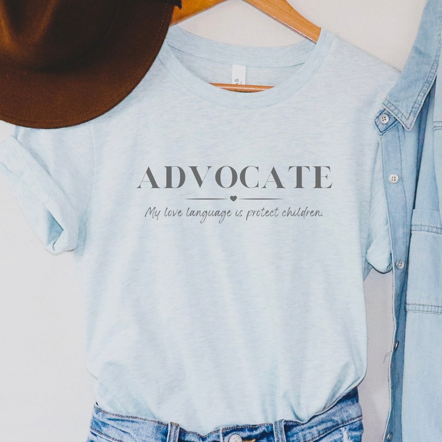 Front and center, the bold message declares, "ADVOCATE: my love language is protect children." This impactful phrase encapsulates the essence of your commitment to safeguarding children and promoting their well-being. Perfect for child advocates, champions of children’s mental health, and for Child Abuse Awareness and Prevention Month