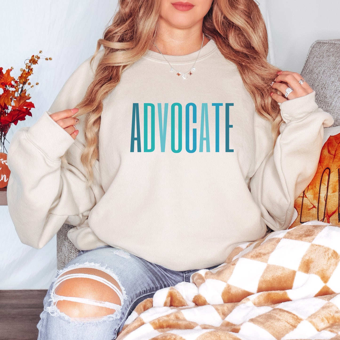 The front of the sweatshirt proudly displays the word ADVOCATE in a bold and eye catching font in varying shades of blue which is the color of child advocacy. It is a wearable symbol of your dedication to a world where all children are loved, cherished, and protected.