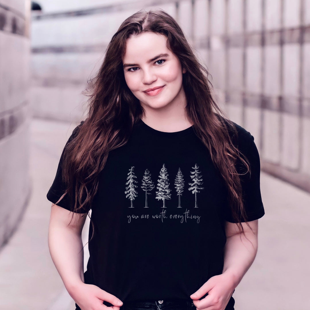Adorned with beautiful enchanting winter pine trees graphic and the empowering affirmation message You Are Worth Everything, this Tshirt is a wearable reminder of your inherent value worth and uniqueness. Perfect gift for mom, advocate, social worker