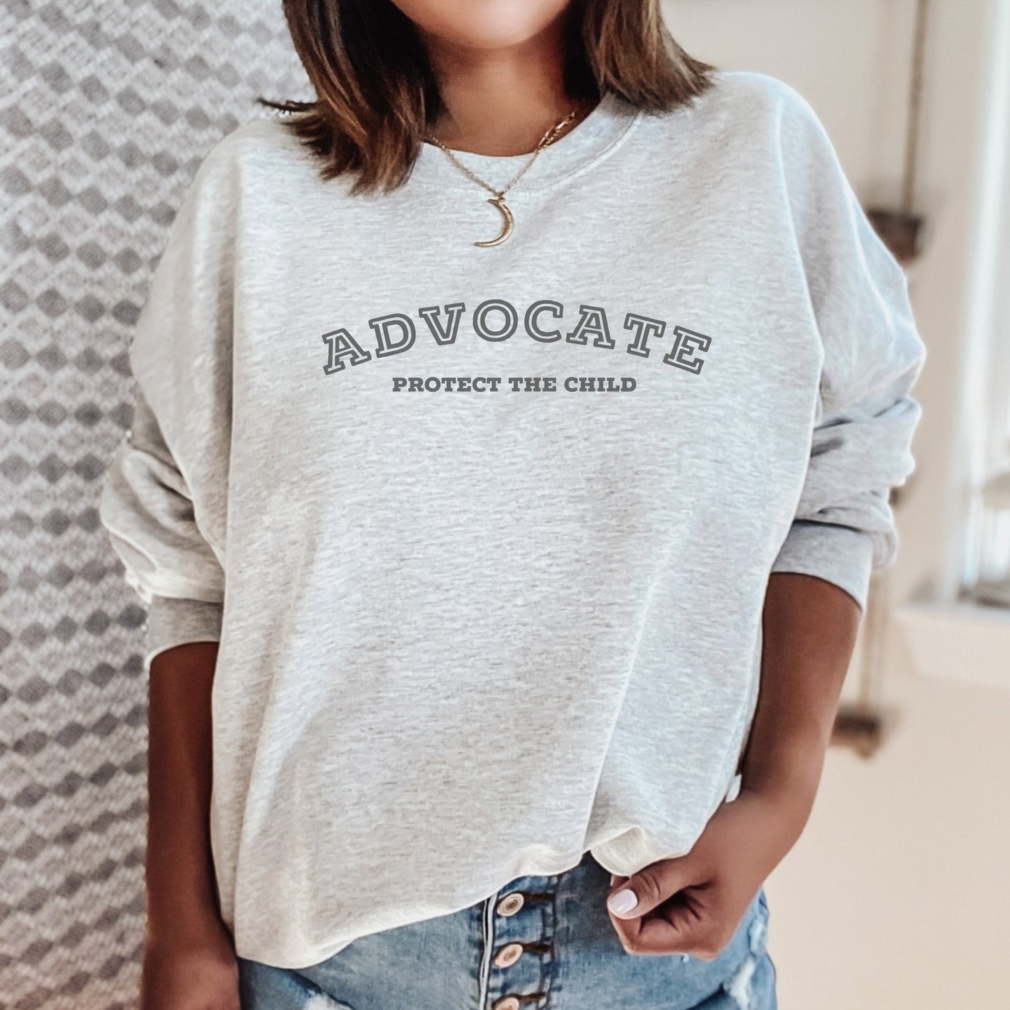 The front of the sweatshirt proudly displays the phrase "Advocate Protecct The Child" in a bold and eye-catching font. Crafted for child advocates and champions of children's mental health, and perfect for Child Abuse Awareness and Prevention Month!