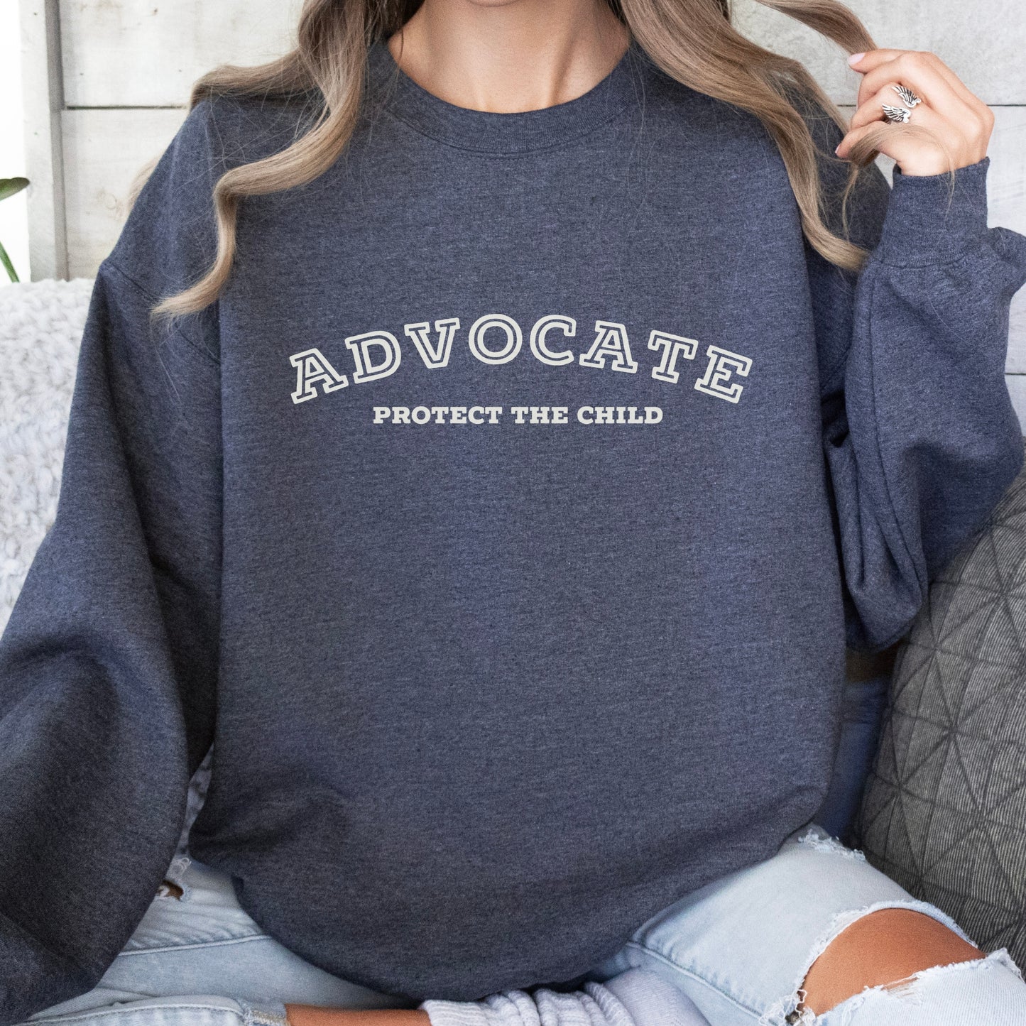 The front of the sweatshirt proudly displays the phrase "Advocate Protecct The Child" in a bold and eye-catching font. Crafted for child advocates and champions of children's mental health, and perfect for Child Abuse Awareness and Prevention Month!