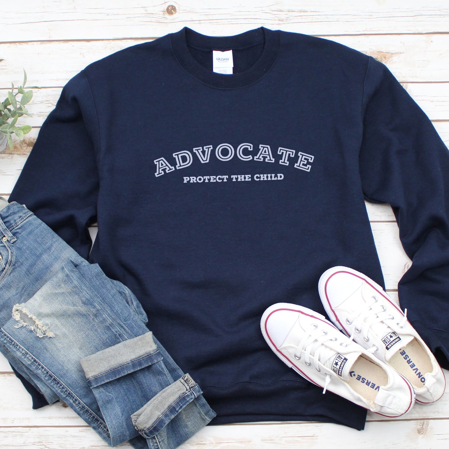 The front of the sweatshirt proudly displays the phrase "Advocate Protecct The Child" in a bold and eye-catching font. Crafted for child advocates and champions of children's mental health, and perfect for Child Abuse Awareness and Prevention Month!