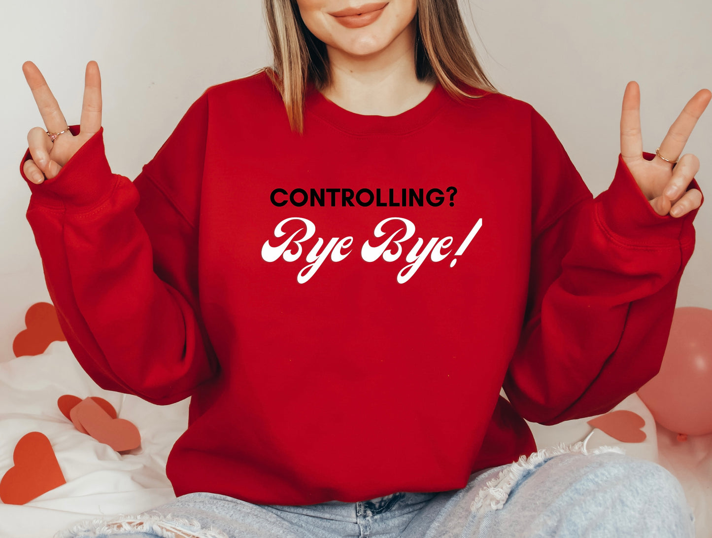 The front of the sweatshirt proudly displays the phrase "Controlling? Bye Bye!" in a bold and eye-catching font. This message serves as a reminder that love is not controlling. Tailored for domestic violence and teen dating violence advocates.