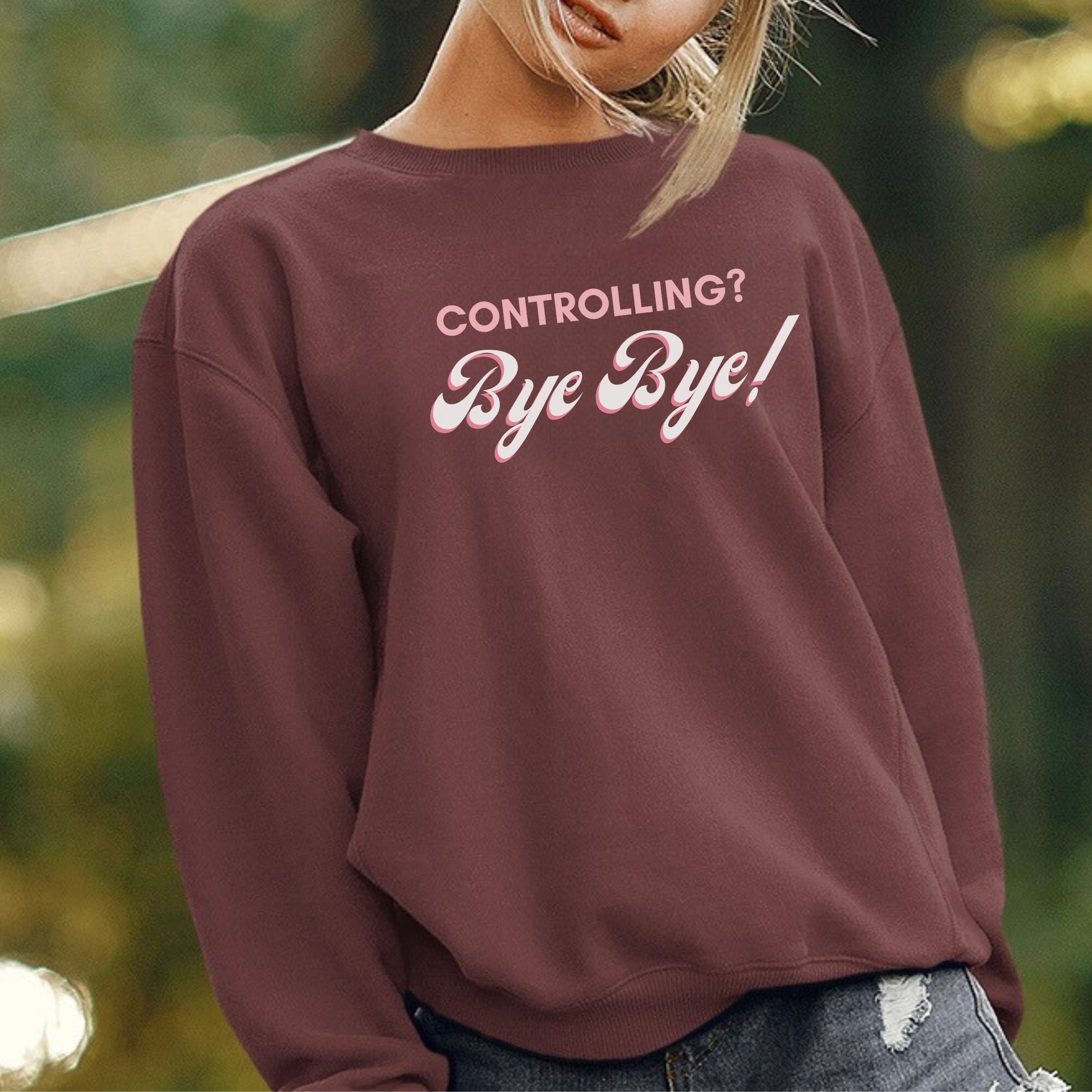 The front of the sweatshirt proudly displays the phrase "Controlling? Bye Bye!" in a bold and eye-catching font. This message serves as a reminder that love is not controlling. Tailored for domestic violence and teen dating violence advocates.
