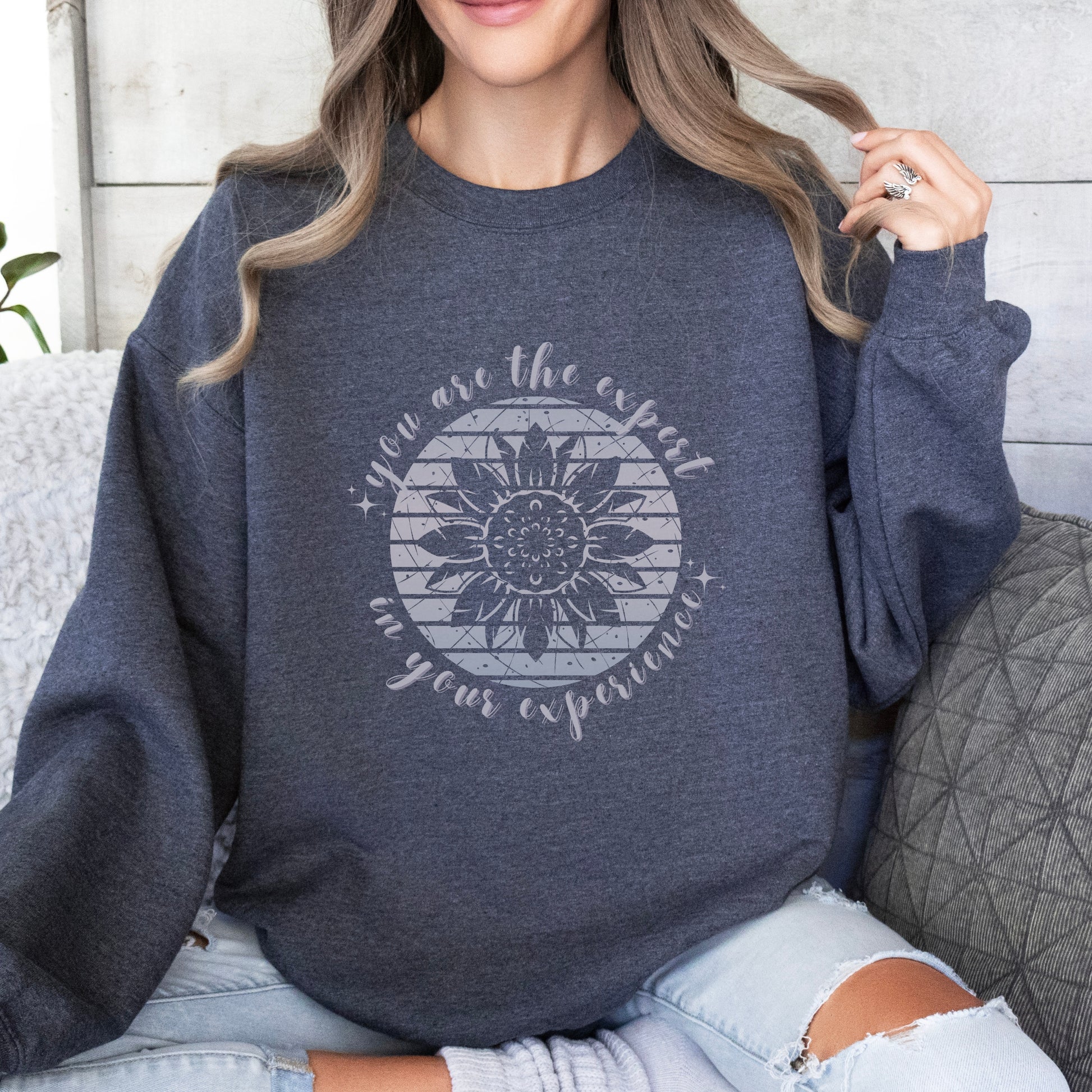 Mental health empowerment with our unique sweatshirt, tailored for survivors and advocates of abuse and trauma. The boho sunflower, a symbol of strength and growth, is surrounded by the powerful message, You are the expert in your experience.