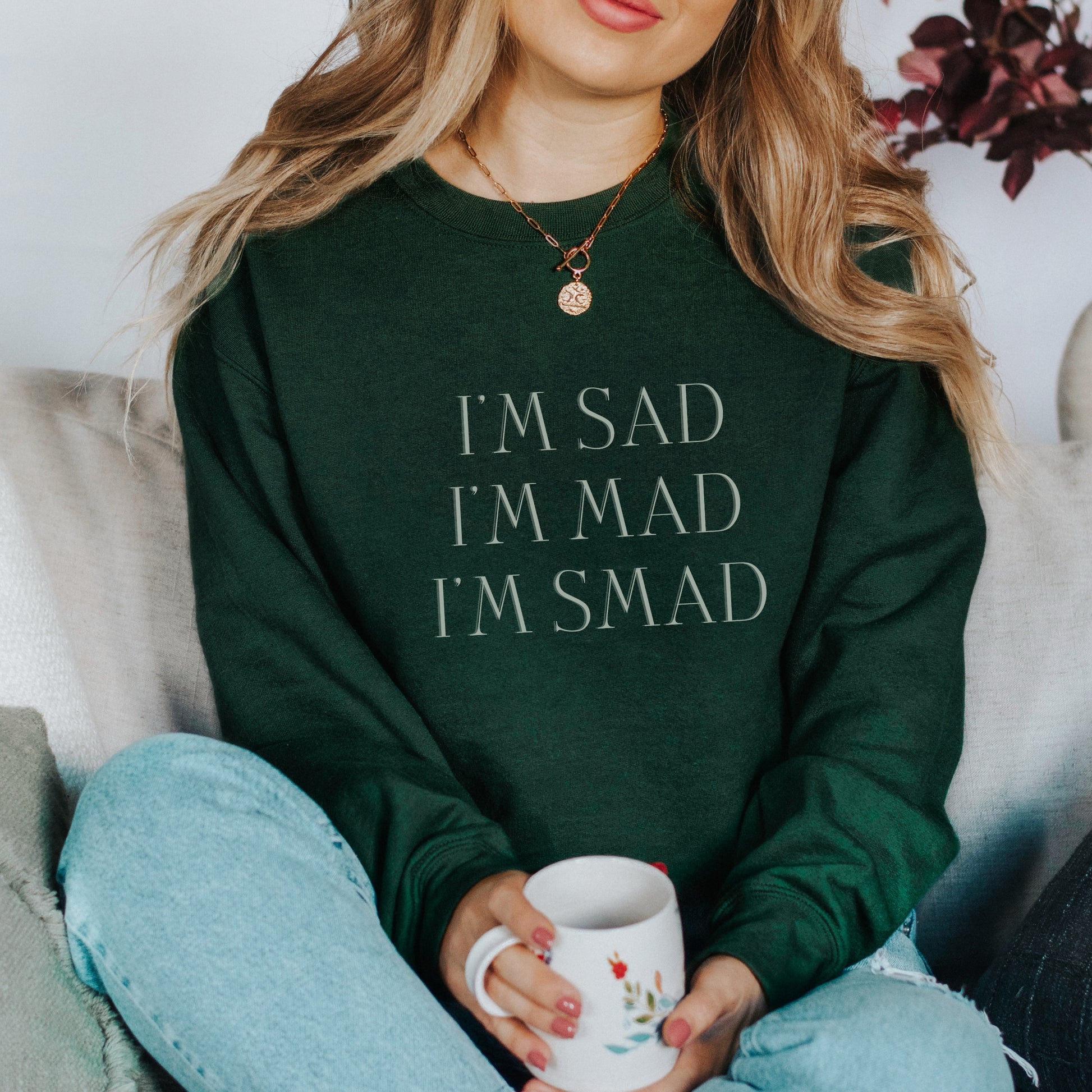 The front of the sweatshirt proudly displays the phrase "I’m Sad. I’m Mad. I’m Smad." in a bold and eye-catching font. The design is not just a fashion statement; it's a conversation starter that promotes mental health awareness and destigmatizes the spectrum of feelings we all experience.