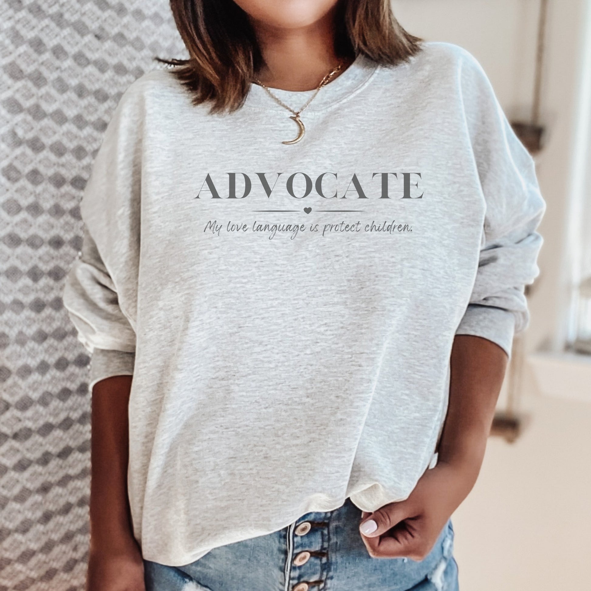 Front and center, the bold message declares, "ADVOCATE: my love language is protect children." This impactful phrase encapsulates the essence of your commitment to safeguarding children and promoting their well-being. Perfect for child advocates, champions of children’s mental health, and for Child Abuse Awareness and Prevention Month