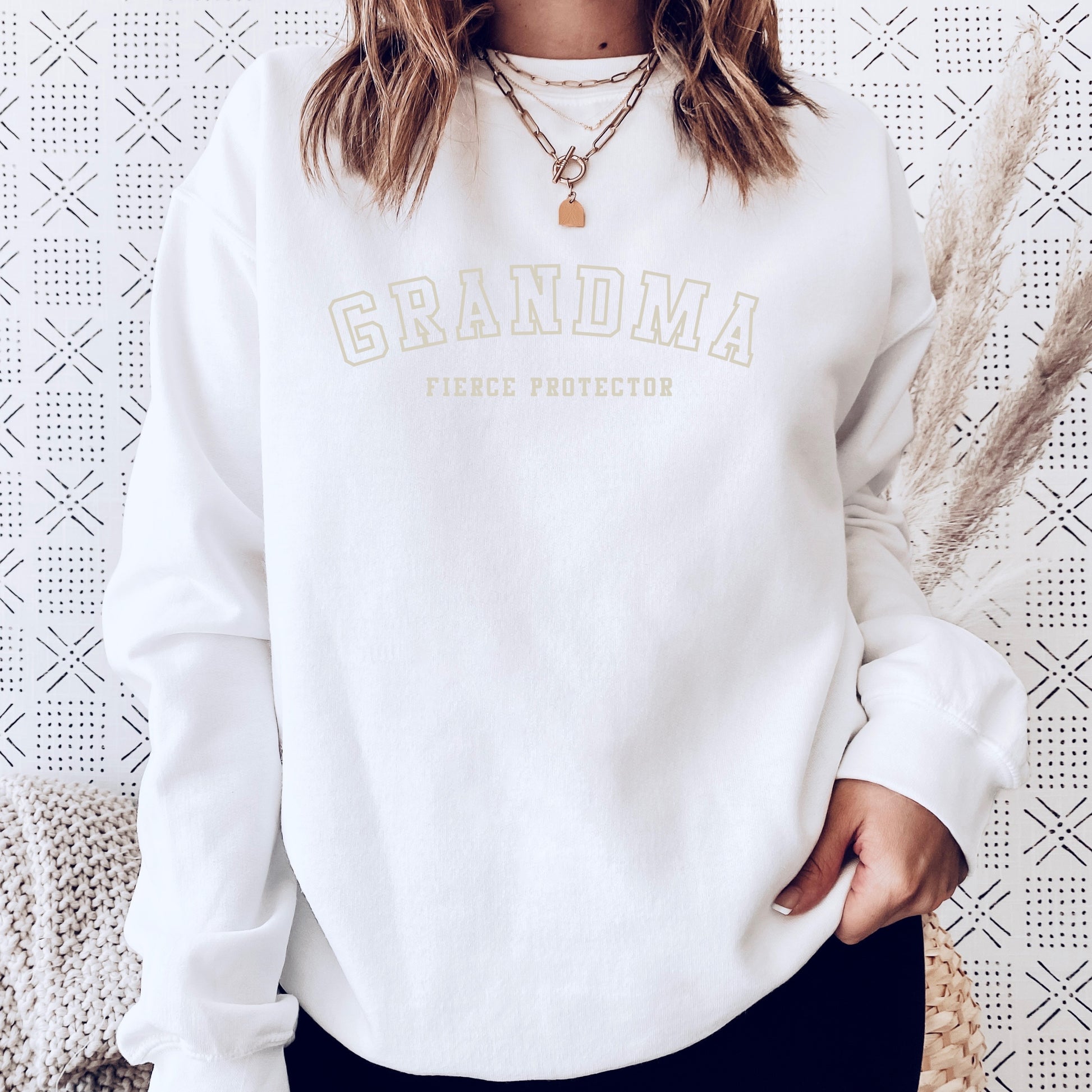 The front of the sweatshirt proudly displays the phrase Grandma Fierce Protector in a bold and eye catching font. This message serves as a reminder that we reject victim blaming and support those who have faced injustice. Your grandma can wear her strength proudly, embracing both comfort and empowerment.