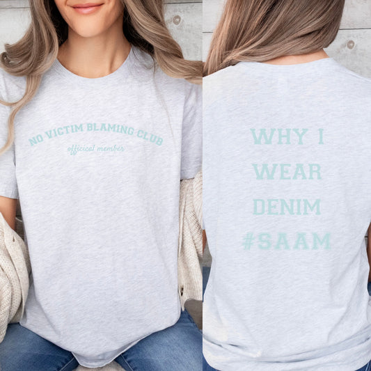 The front of the T-shirt has the empowering saying in teal, ‘No Victim Blaming Club Official Member’, and the back says ‘Why I Wear Denim #SAAM’. Designed to support survivors and end victim blaming during April’s Sexual Assault Awareness Month and Denim Day.