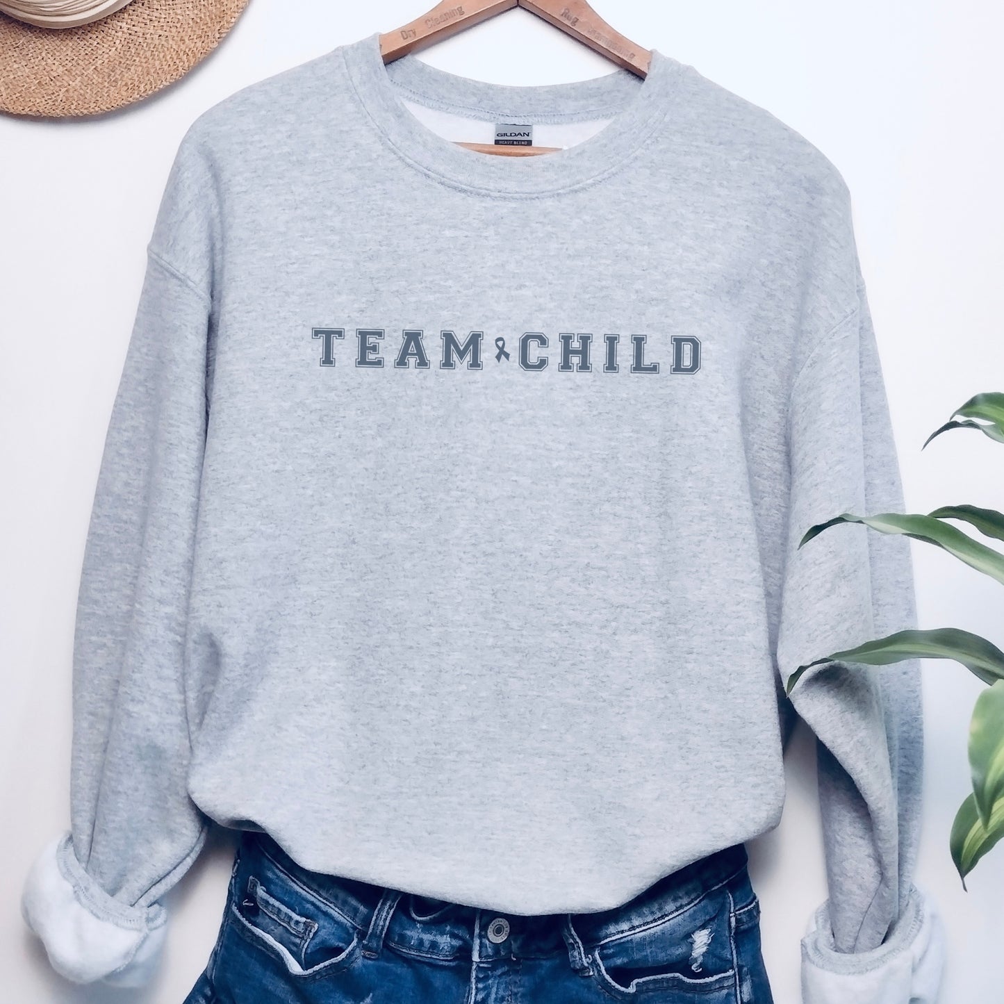 Our exclusive sweatshirt has ‘Team Child’ on the front in a bold font with the blue child abuse awareness ribbon between the words. This impactful phrase encapsulates the essence of your commitment to safeguarding children and promoting their well-being. Perfect for child advocates, champions of children’s mental health, and for Child Abuse Awareness and Prevention Month (CAPM)