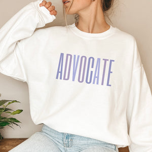 White crewneck sweatshirt with a powerful  "ADVOCATE" wordmark emblazoned across the chest in varying shades of purple, symbolizing the strength and unity of domestic violence advocates. The gradient effect from deep violet to lavender adds an eye-catching touch, making this sweater a visually compelling tribute to your commitment to ending domestic abuse.