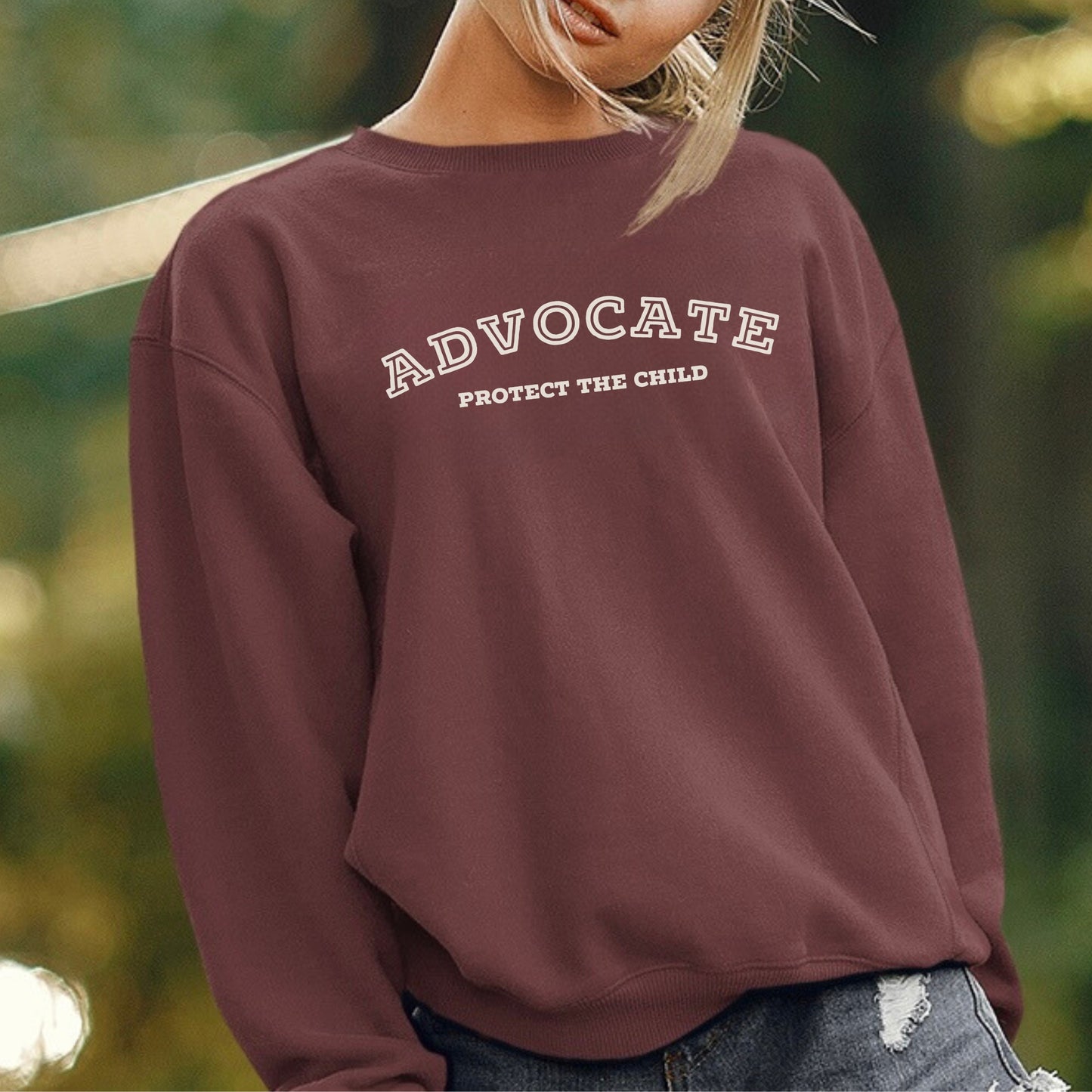 The front of the sweatshirt proudly displays the phrase "Advocate Protecct The Child" in a bold and eye-catching font. Crafted for child advocates and champions of children's mental health, and perfect for Child Abuse Awareness and Prevention Month!