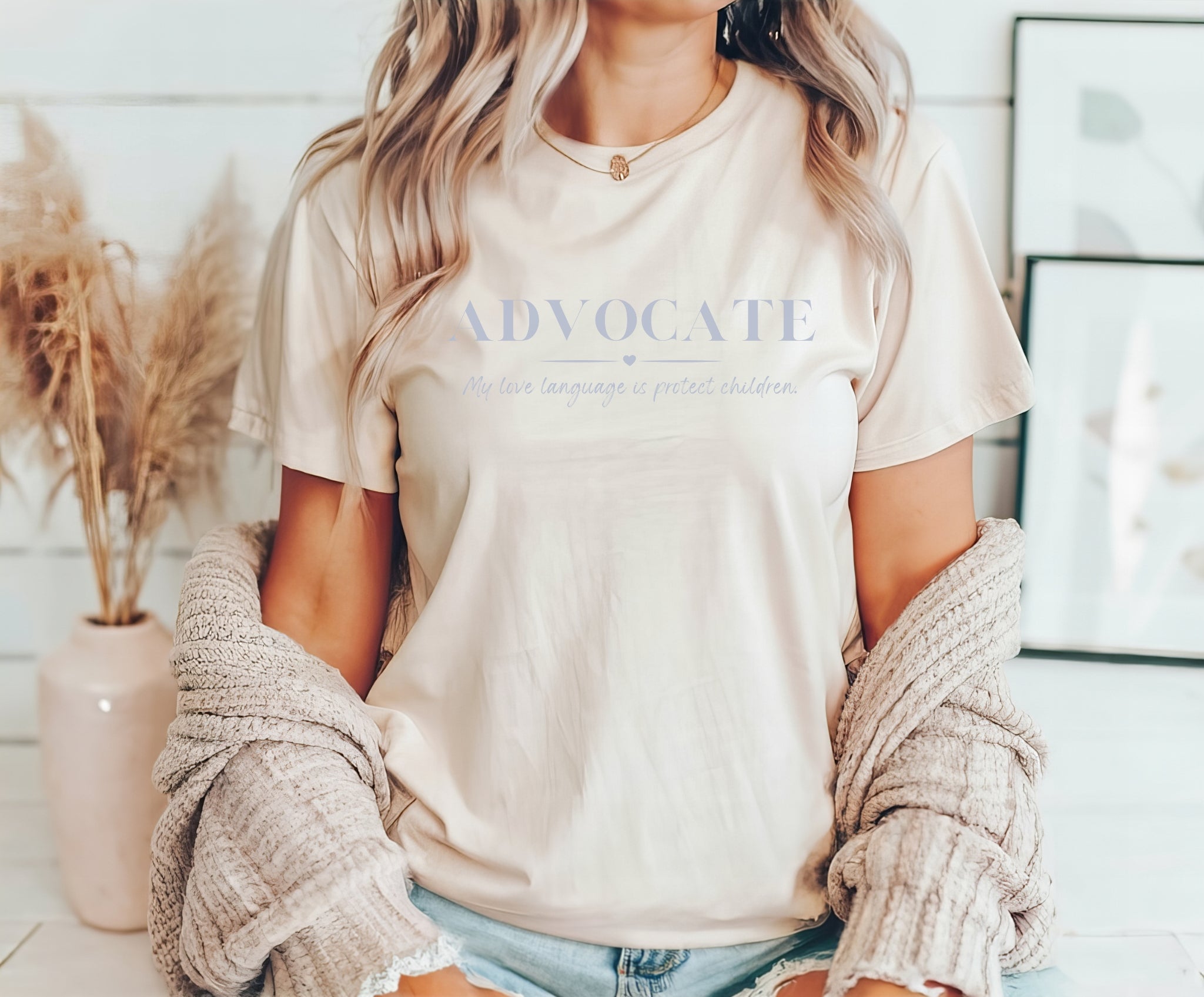 The front of the t-shirt says ADVOCATE my love language is protect children. Perfect for child advocacy, child advocates, and children's mental health advocates